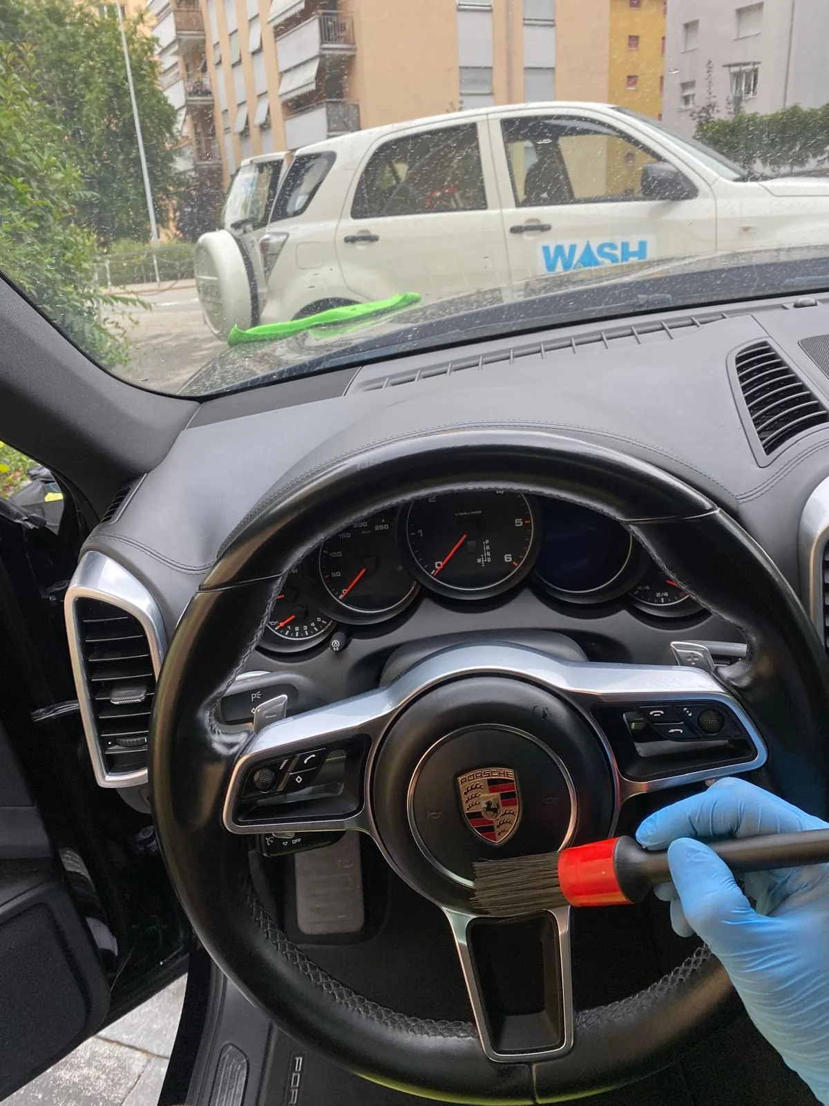 Volante Porsche Cayenne pulito con pennello detailing e guanto nitrile